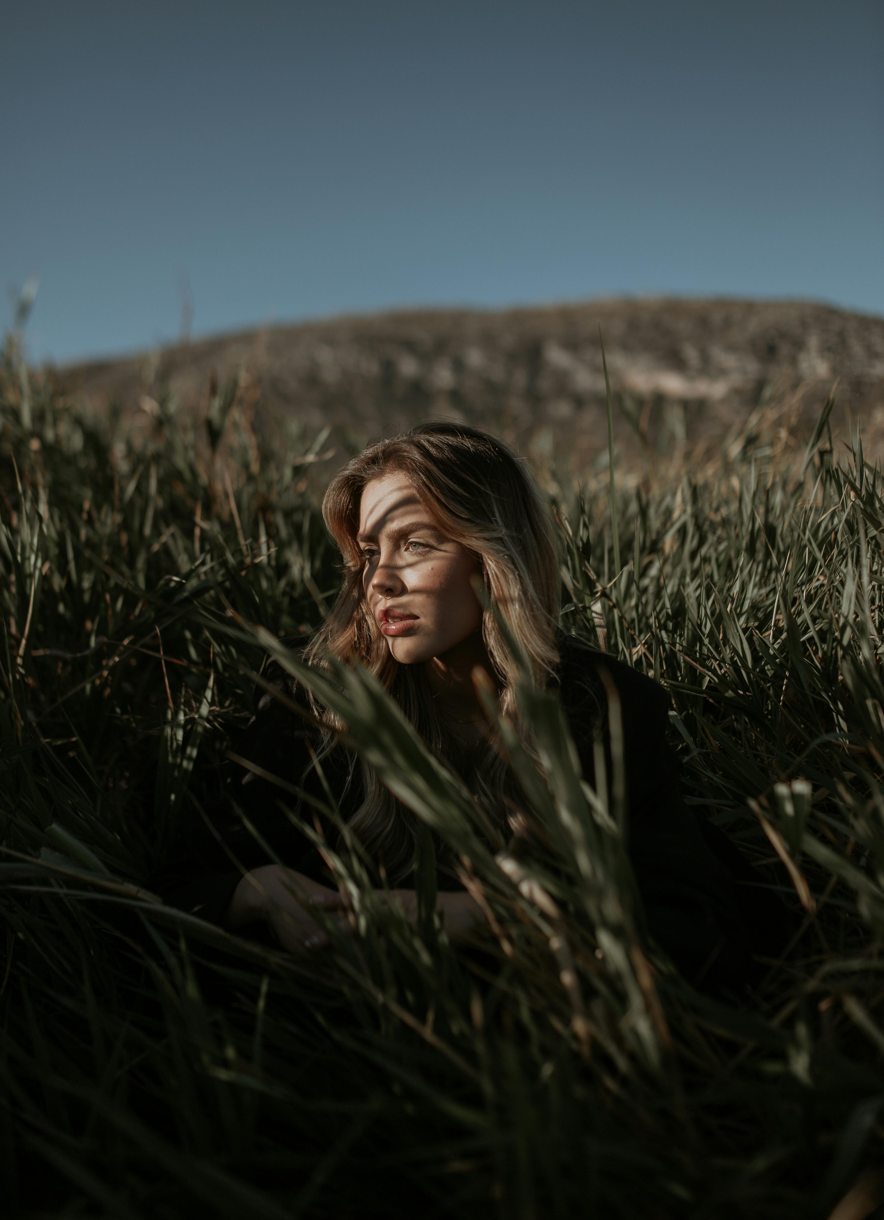 young woman sitting on a grass field