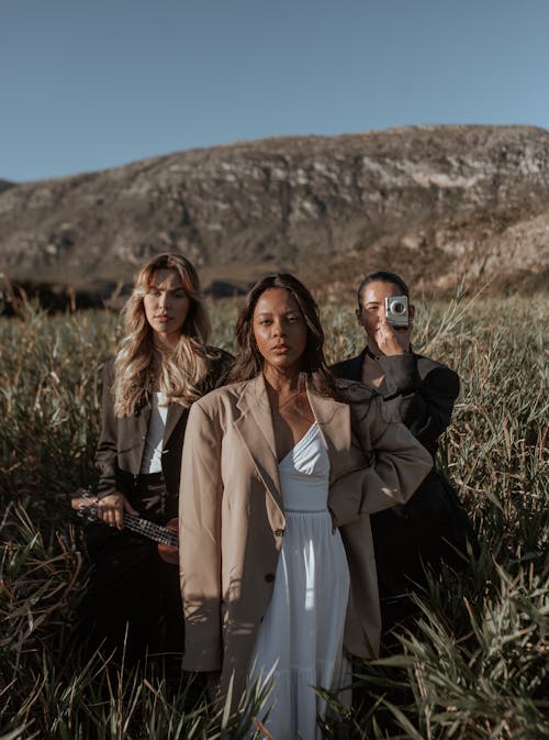 A Group of Women Posing on a Grass Field 