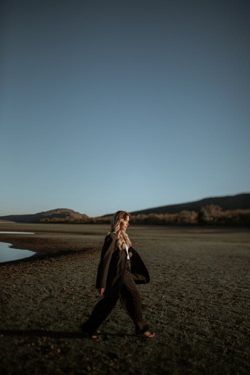Blonde Woman Walking in Black Suits
