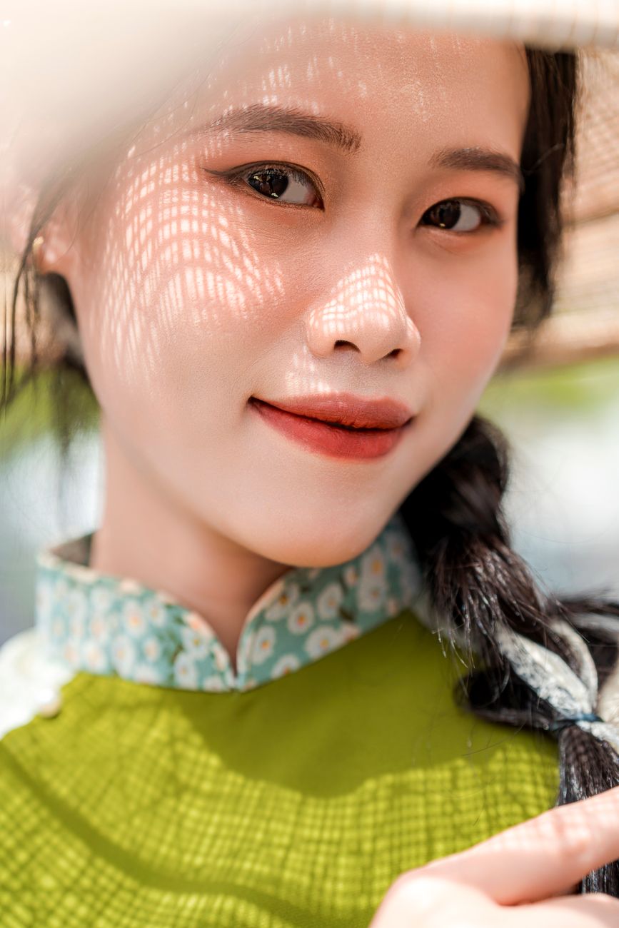 Close-up portrait of a smiling woman in traditional Vietnamese attire in Ho Chi Minh City.