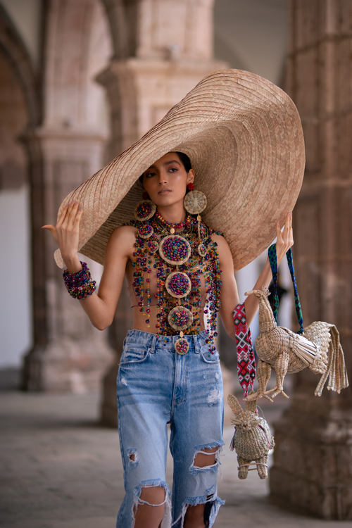Free A woman in vibrant fashion poses with a large hat and traditional items in Morelia, Mexico. Stock Photo