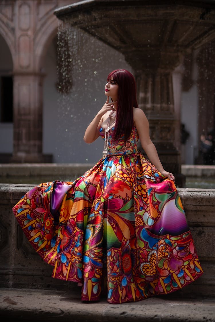 Woman Posing In Colorful Dress By Fountain