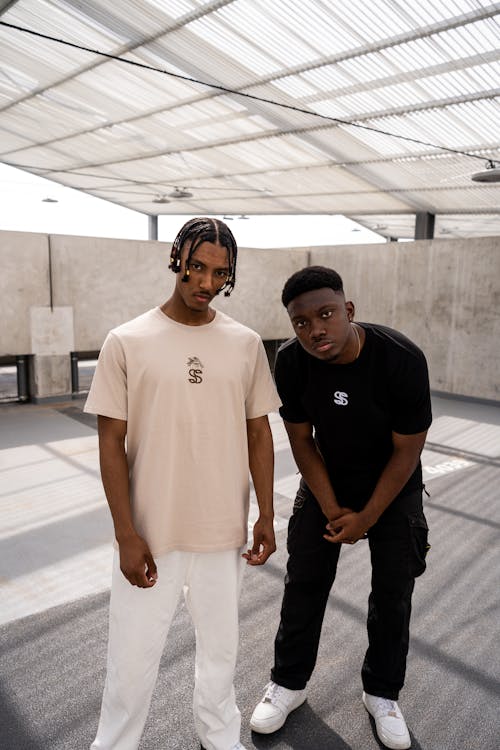 Young Men in Trendy Outfits Standing in a Modern Building 