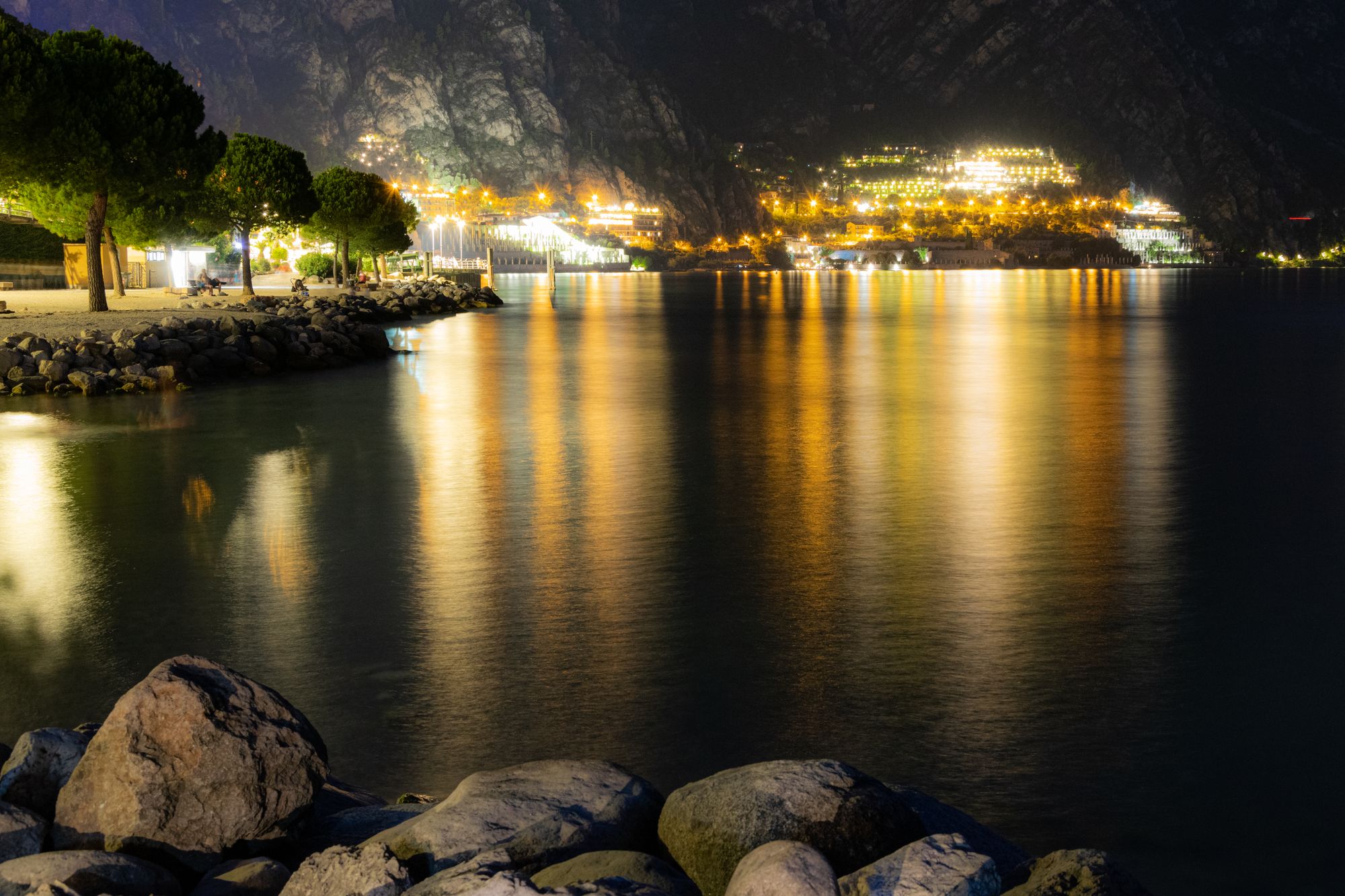Stunning night view of Limone Sul Garda with lake reflections and glowing town lights.