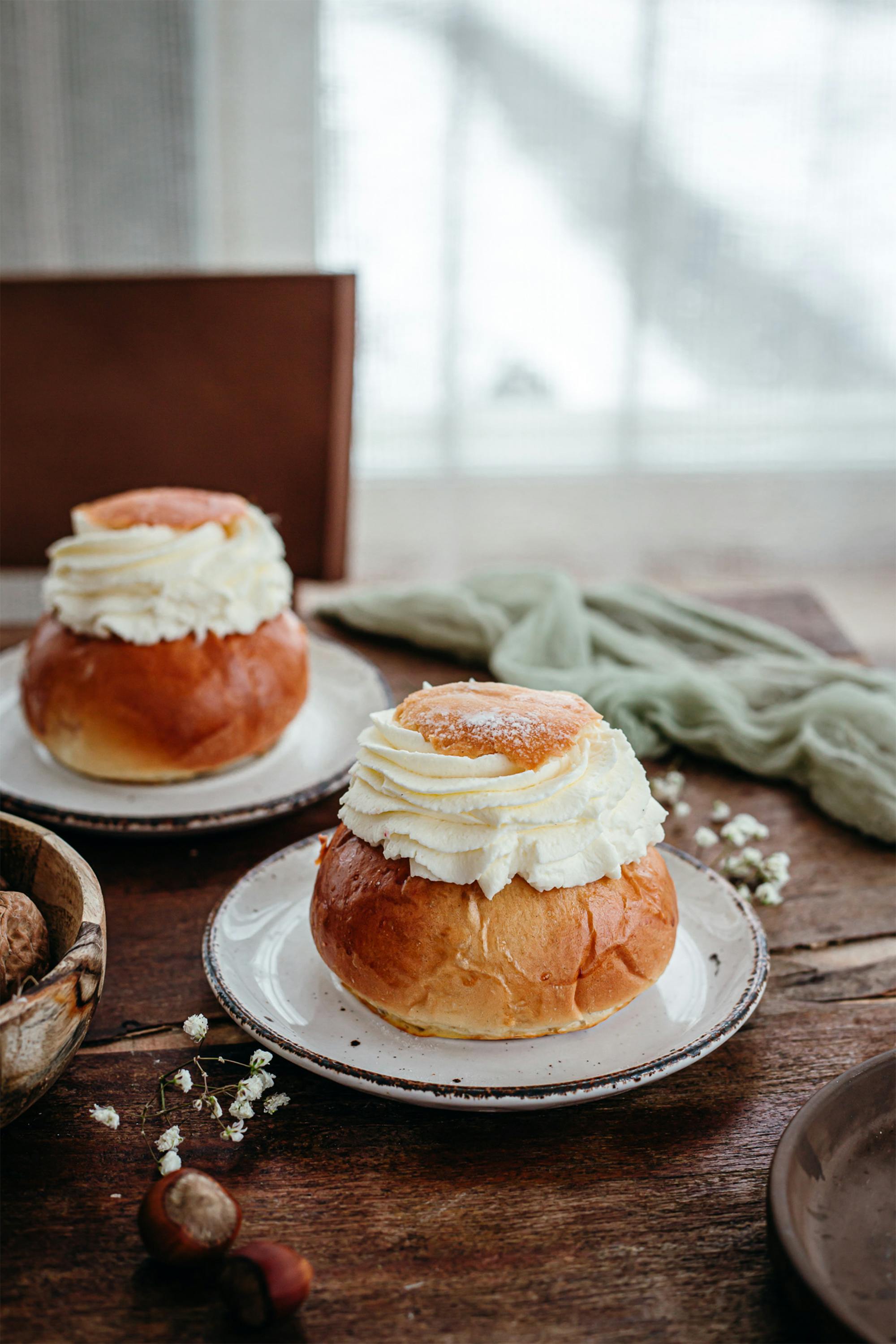 Scrumptious cream-filled buns beautifully presented on a wooden table, perfect for dessert lovers.