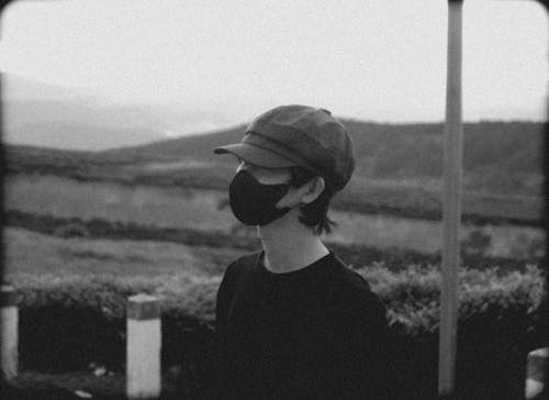 Man in Cap and Mask in Black and White