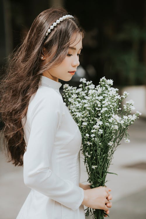 Woman in Wedding Dress and with Flowers