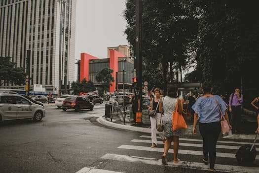 Dynamic urban street scene in Sao Paulo with pedestrians crossing and lively city traffic.
