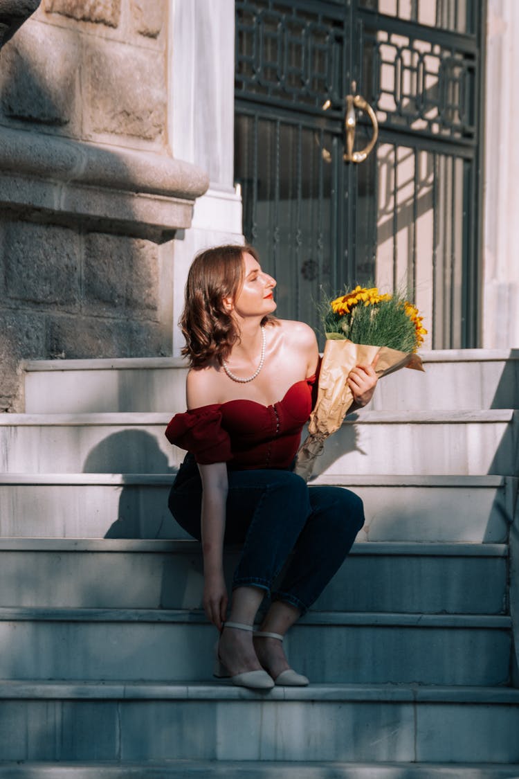 Woman Sitting And Posing With Flowers On Stairs