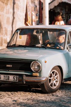 A classic car parked on a cobblestone street, capturing a vintage urban scene in daylight. Perfect for retro city themes.