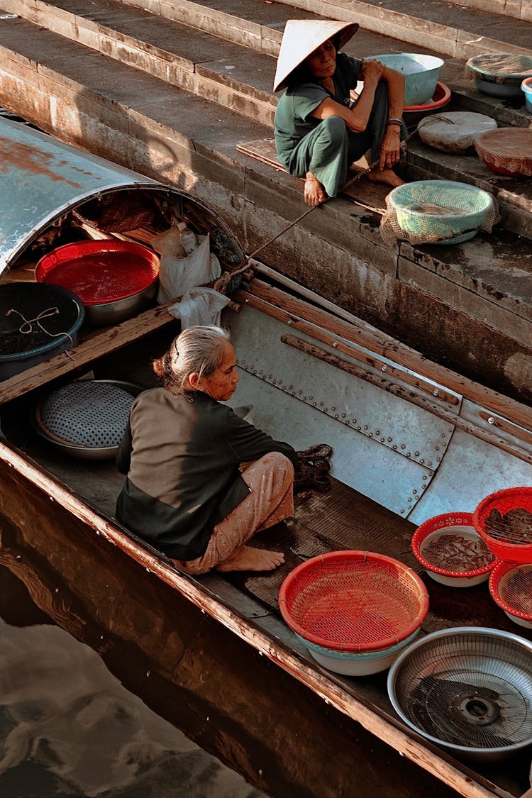 Senior Woman Sitting In A Fishing Boat With Basins