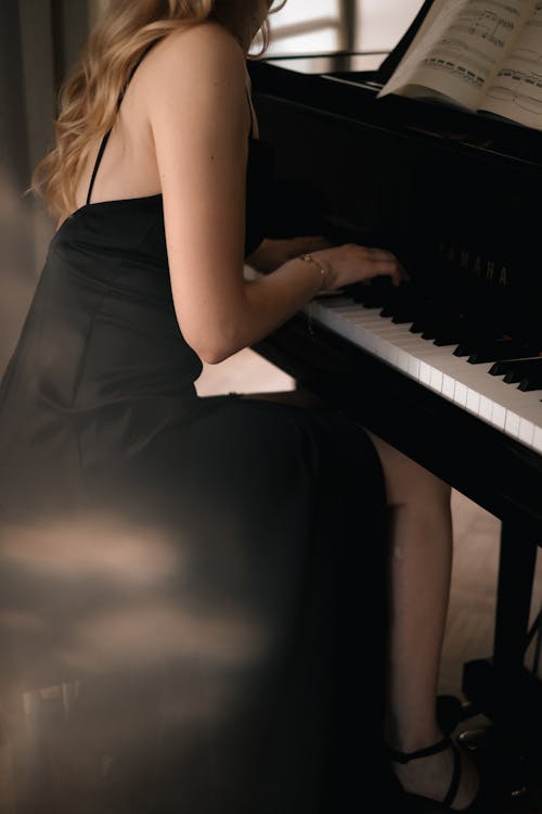 Woman in Black Elegant Dress Playing Piano