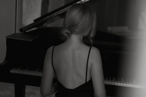 Woman in Strap Dress Sitting at Piano