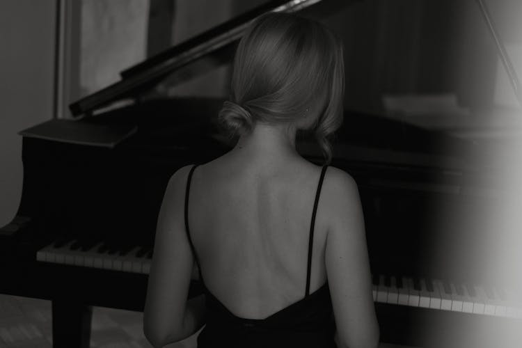 Woman In Strap Dress Sitting At Piano