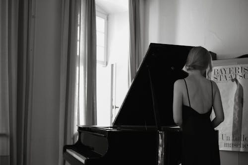 Woman in Dress Standing near Piano