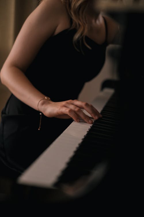 Woman in Strap Dress Playing Piano