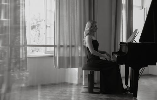 Woman Sitting and Playing Piano in Black and White