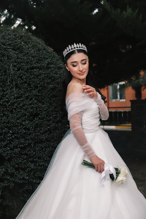 Bride in White Wedding Gown Posing with a Bouquet