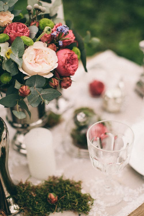 Close-Up Photo of Flowers Near Drinking Glass