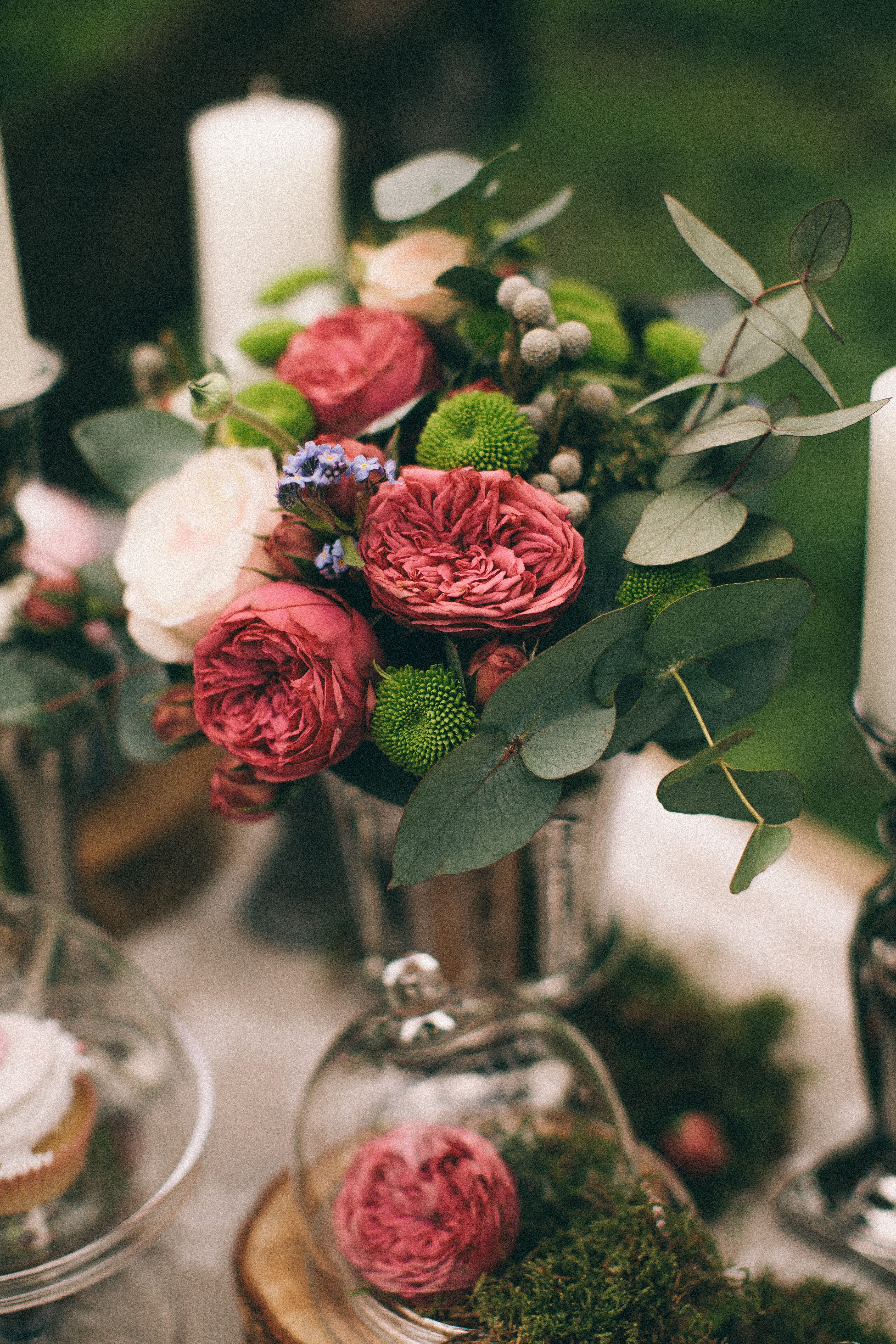 Lavish floral bouquet featuring roses, green moss, and delicate foliage, perfect for decoration or special occasions.
