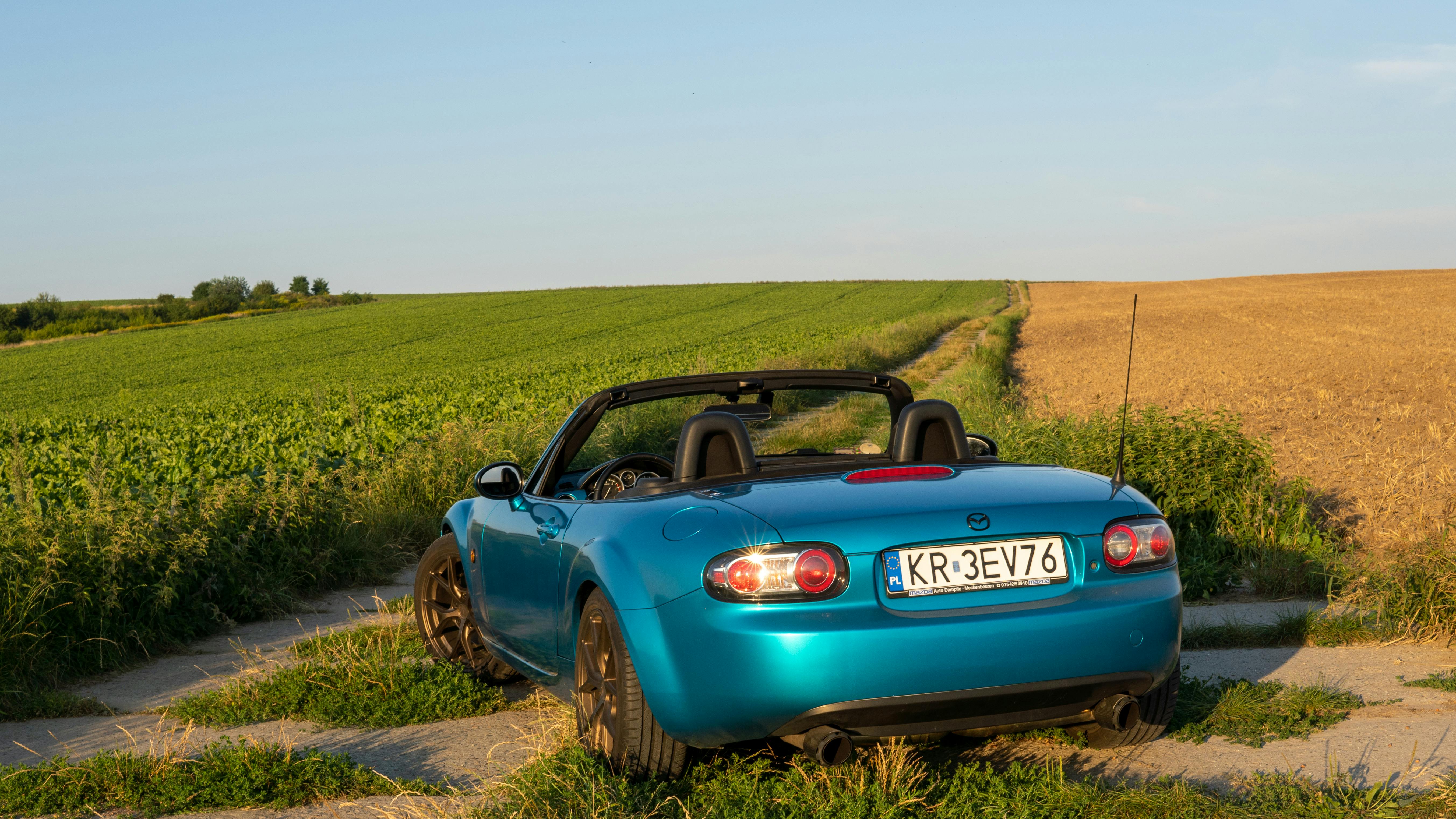 Capture of a blue convertible car on a rural road in Słomniki, Poland.
