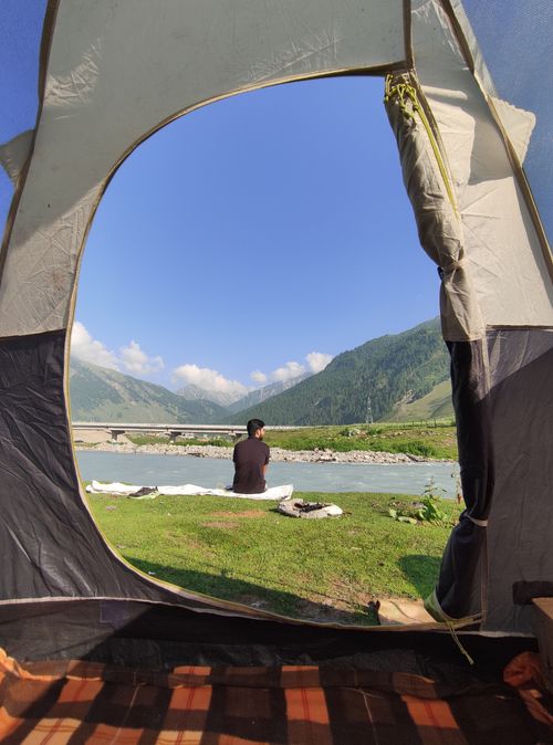 Free Enjoy serene views from a tent by the river in a picturesque valley landscape. Stock Photo
