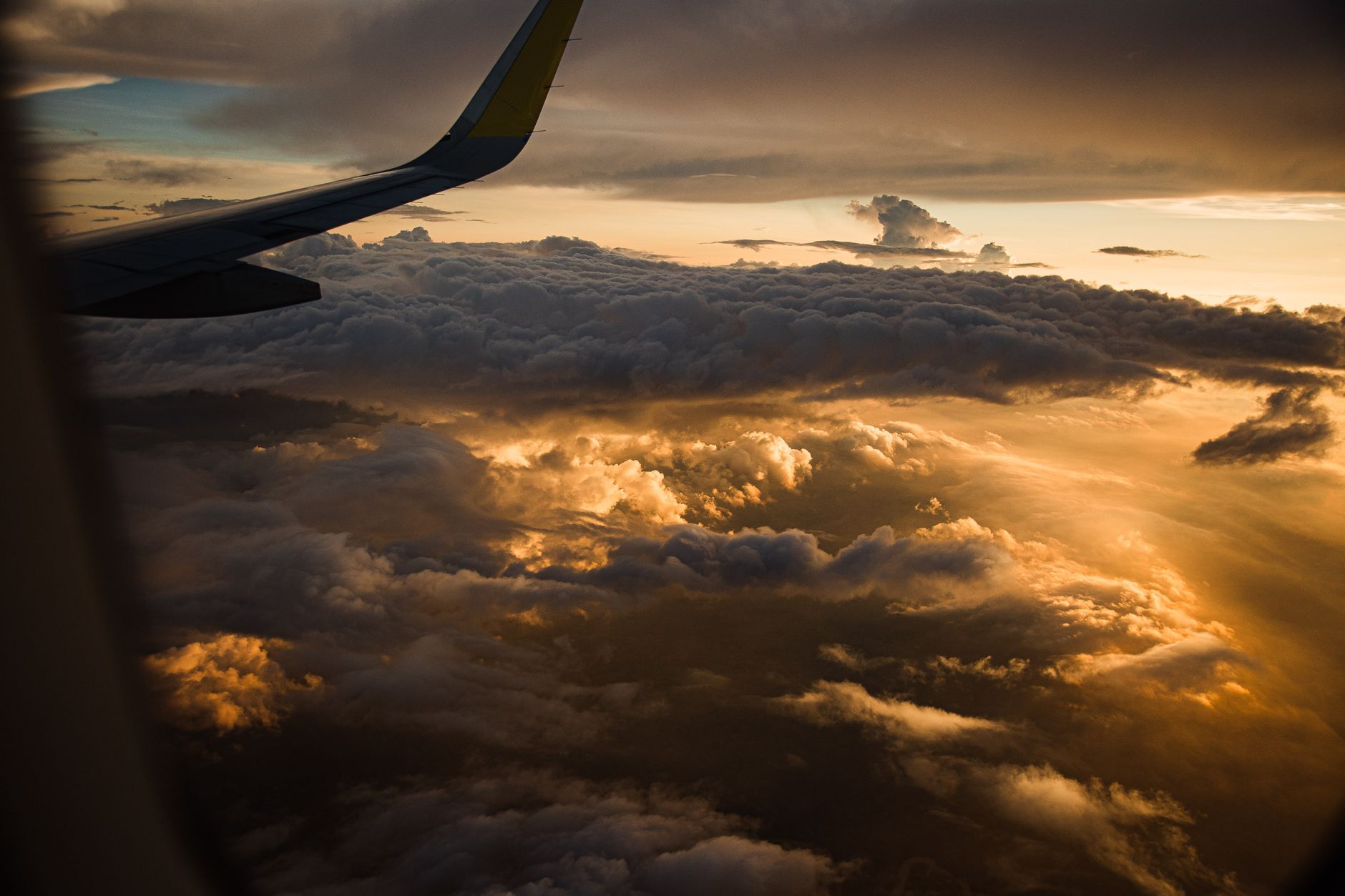 A breathtaking view of clouds and sunset from an airplane window, highlighting the beauty of flight.