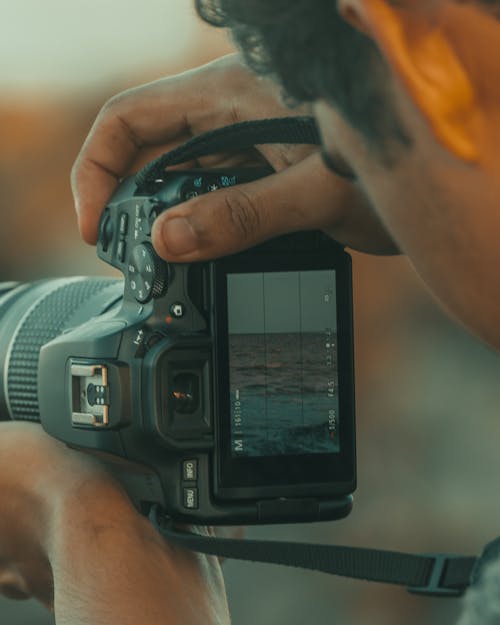 Close-up of a Man Taking a Picture of the Sea 