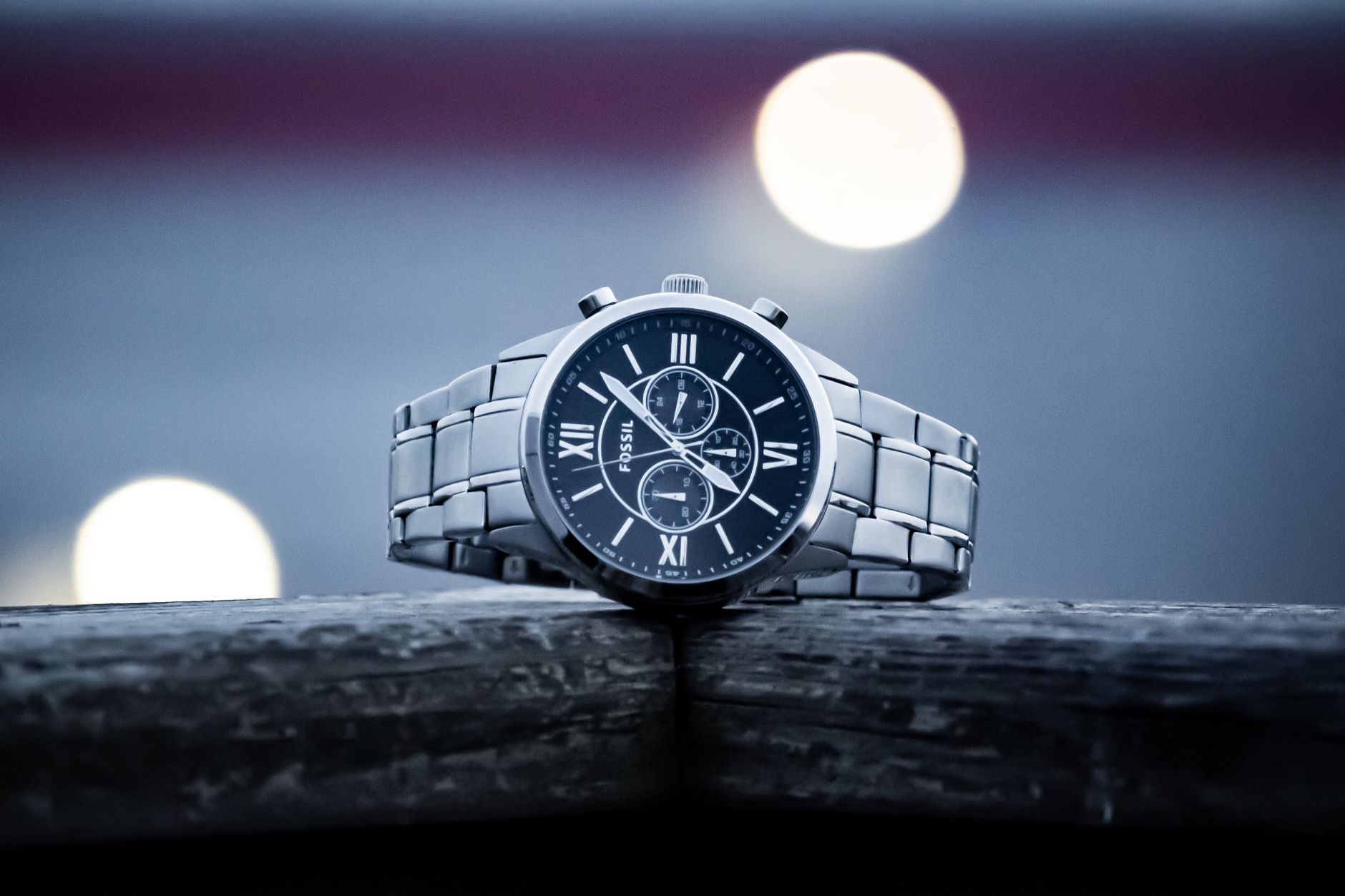 Close-up of a classic silver wristwatch featuring Roman numerals on the face.