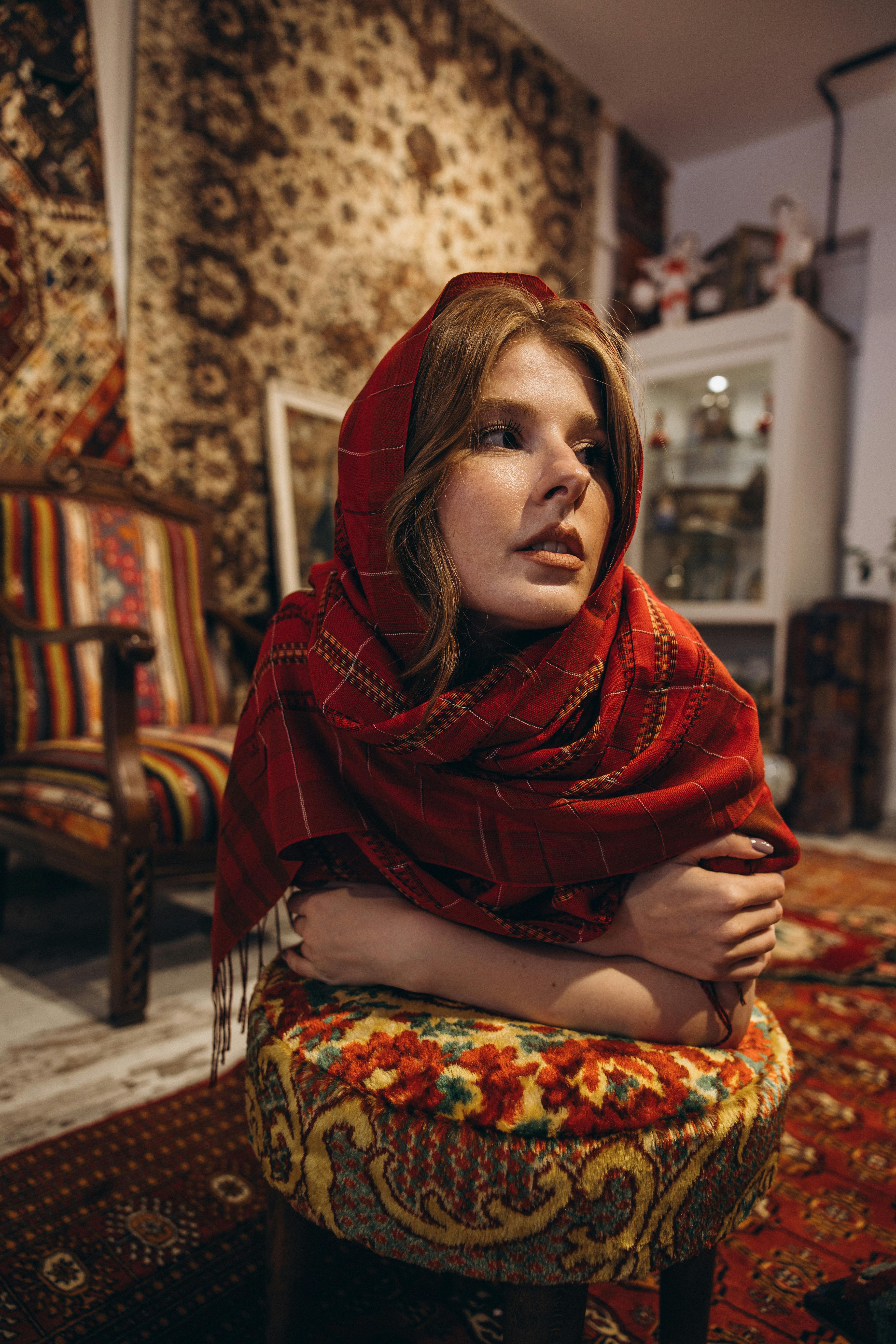 a woman in a red scarf sitting on a chair
