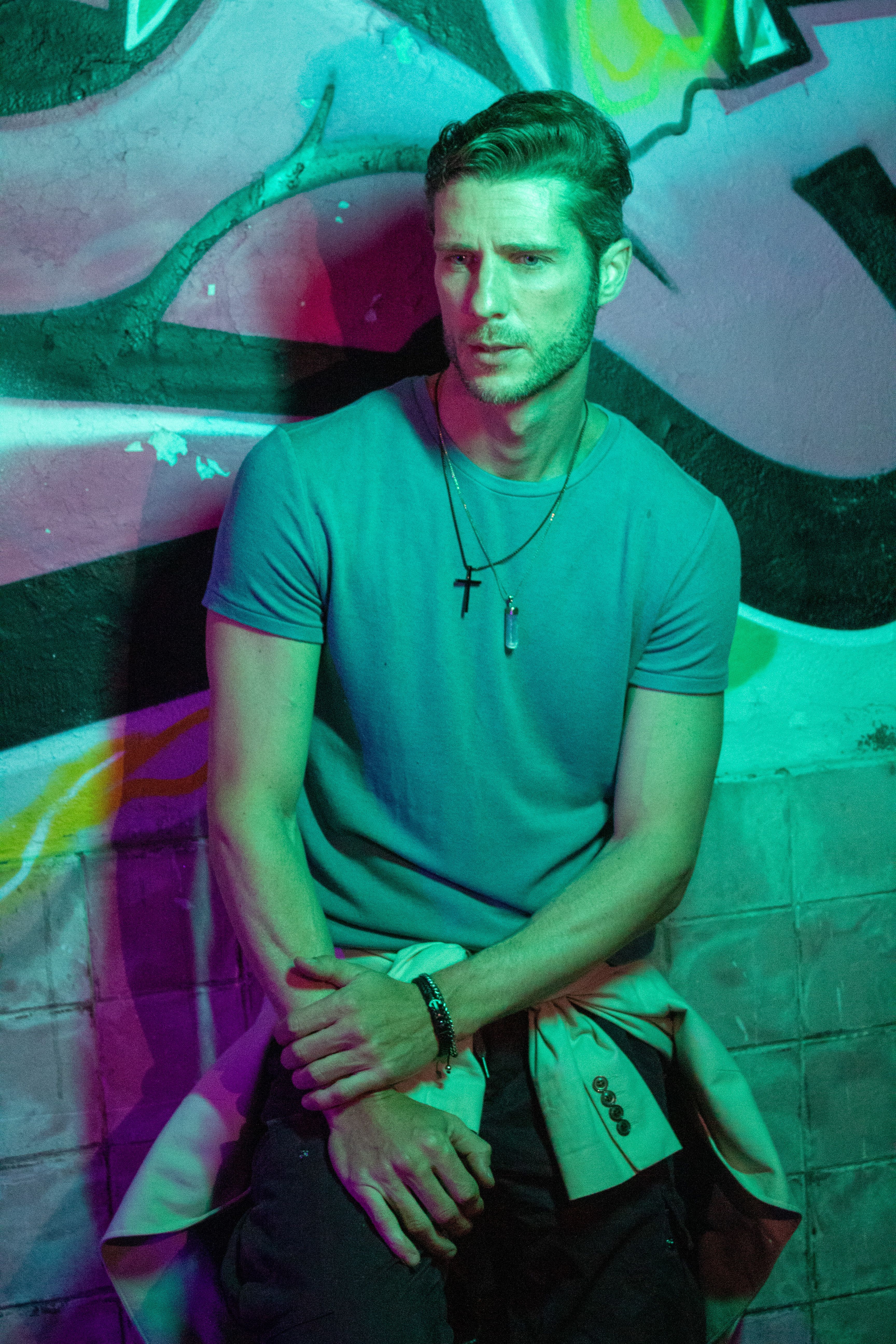 Model posing against vibrant graffiti in a stylish urban setting.