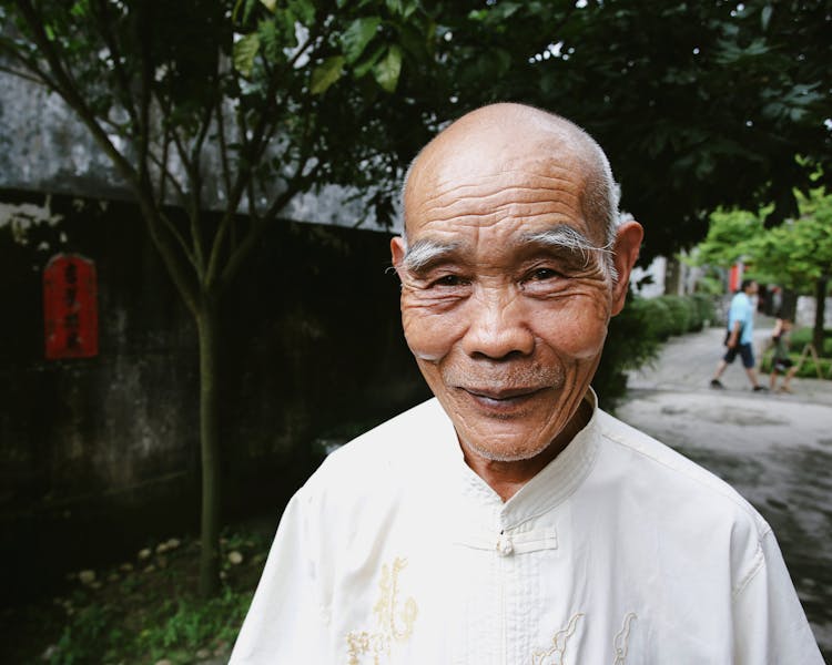 Elderly Man In A Traditional Tang Suit On A Sidewalk