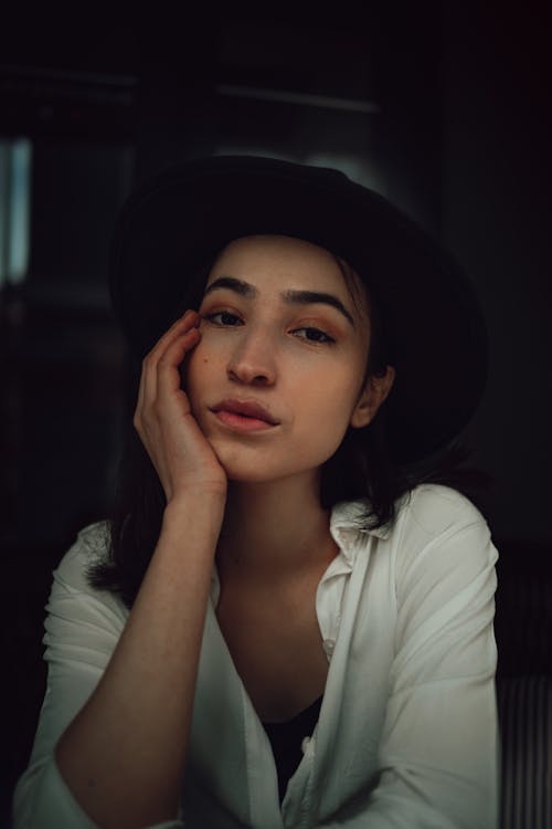 Portrait of a Young Woman Wearing a White Shirt and Black Hat