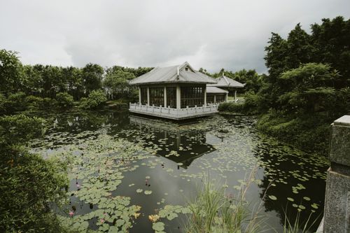 Free Peaceful pavilion in a tranquil park setting by a reflective pond. Stock Photo
