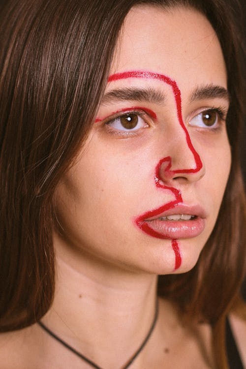 A Portrait of a Young Woman with a Red Line Painted on Her Face 