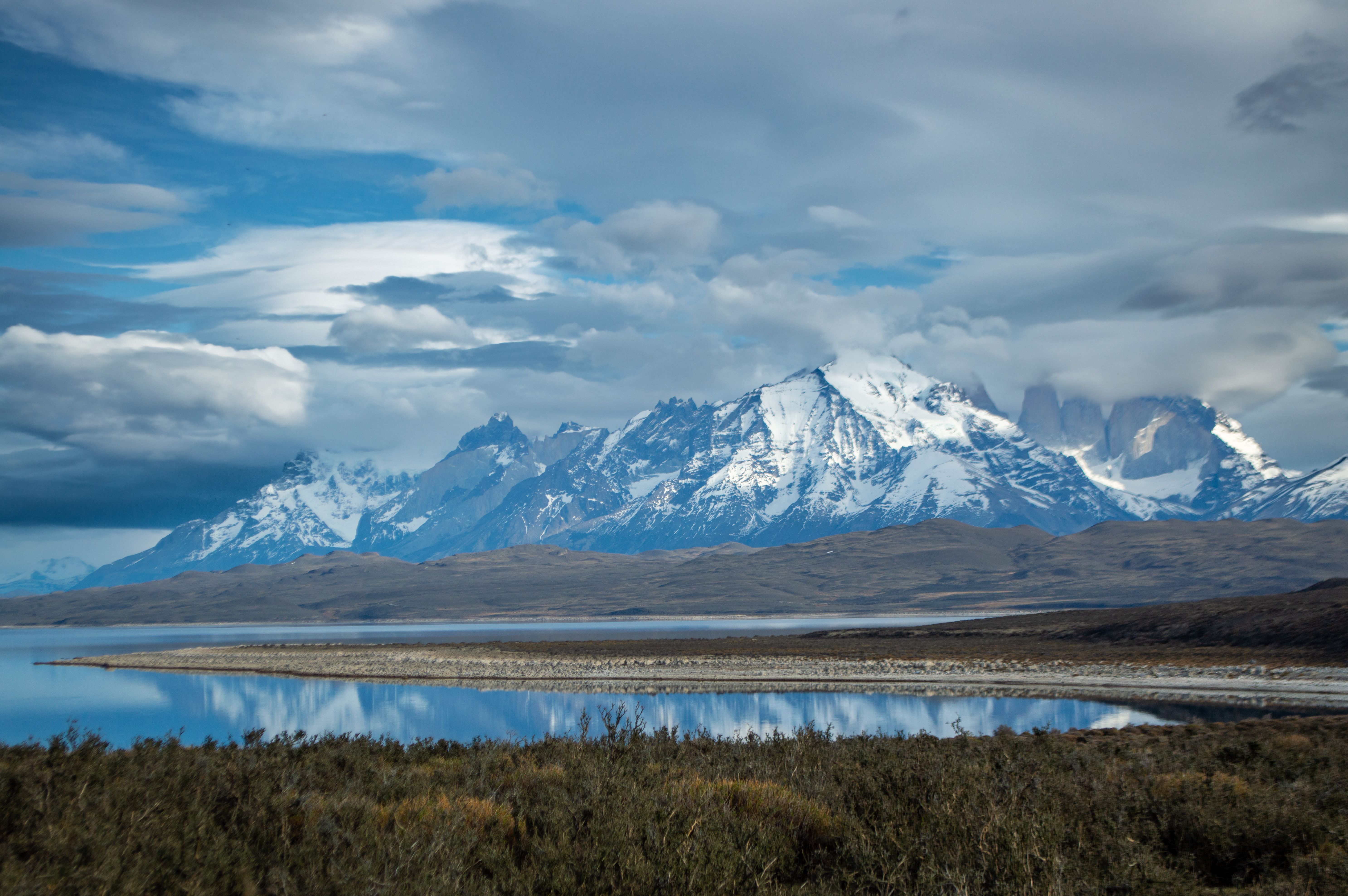Breathtaking view of snowcapped peaks and serene lake at Torres del Paine National Park, Chile.