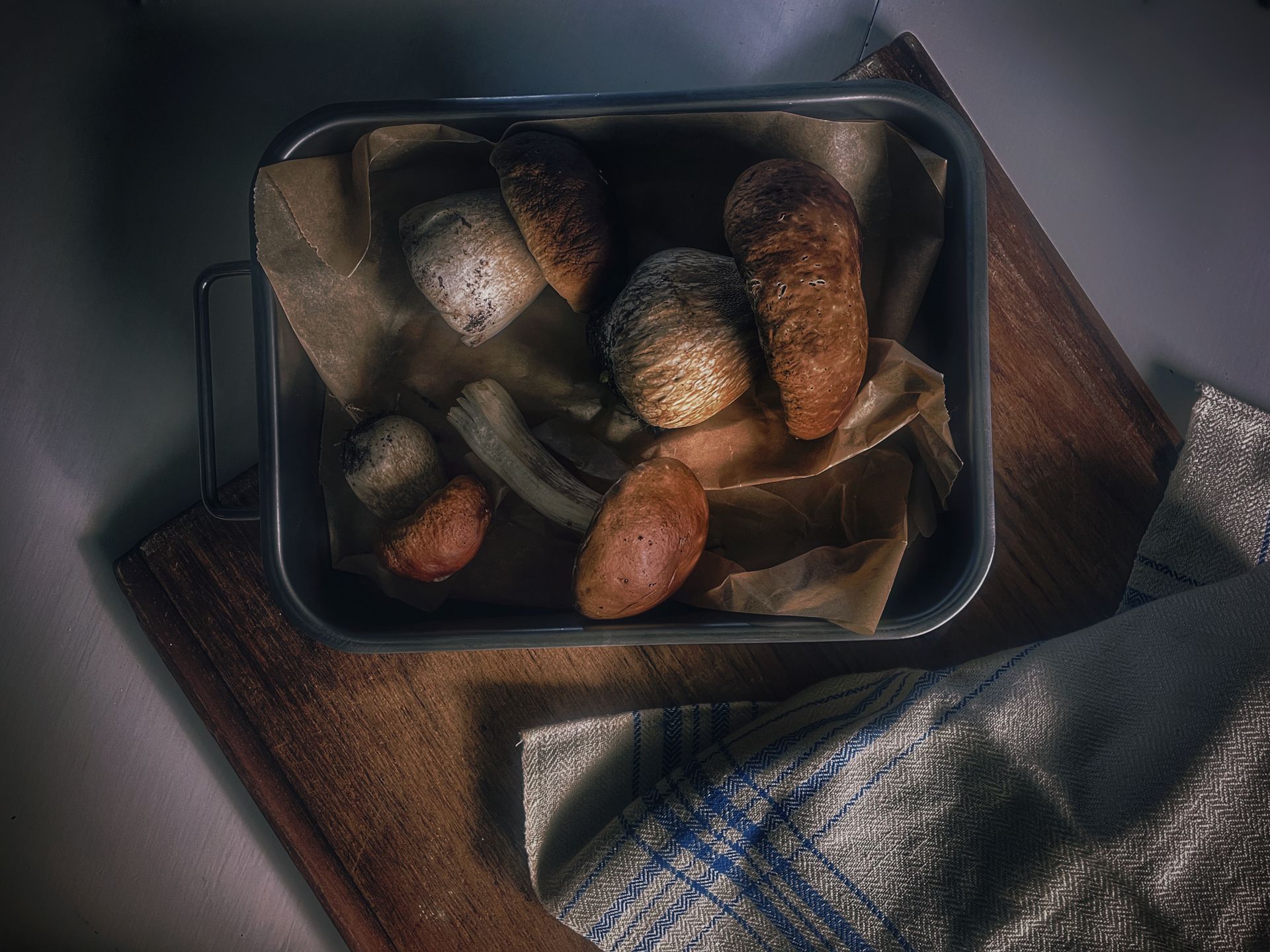 A rustic assortment of fresh mushrooms displayed on a tray in a Swedish kitchen setting.