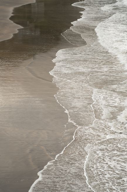 Waves gently lapping the shore at Christchurch beach, a tranquil seaside scene.