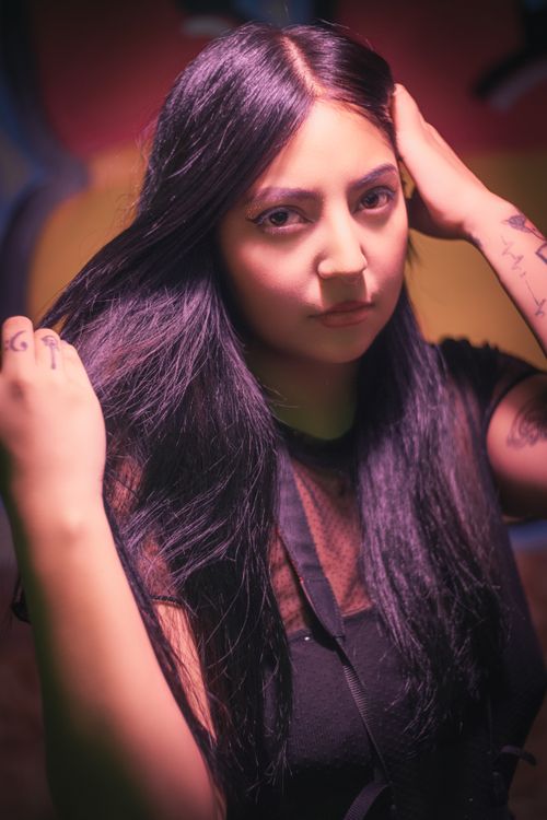 Free Portrait of a woman with long black hair, showcasing tattoos and a modern look. Stock Photo