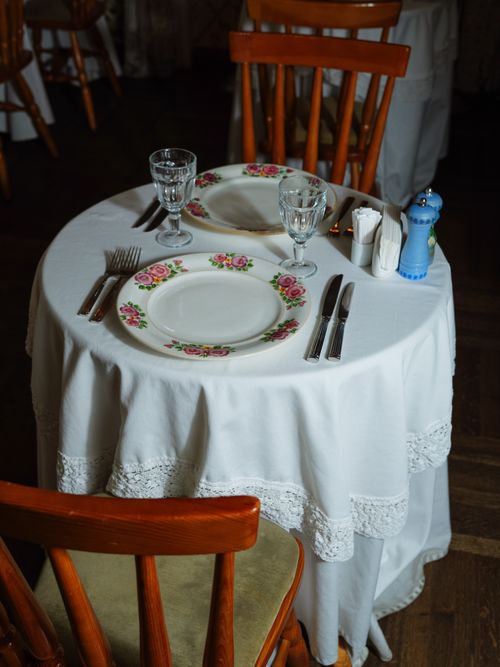 Free Intimate table setting with floral plates and glassware on a white cloth for two. Stock Photo