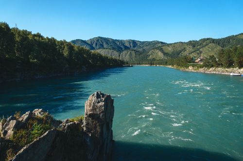 Free Vibrant mountain river landscape with clear skies and lush greenery. Stock Photo