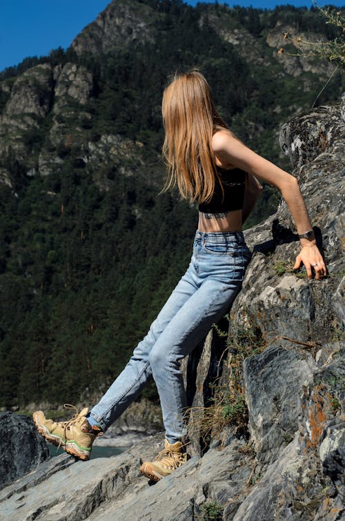 Woman Standing on the Rocky Surface in Mountains 
