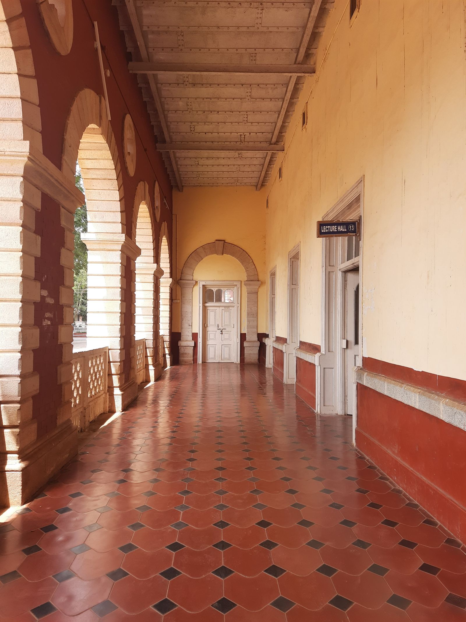 An arched stone corridor on a long-established Indian campus