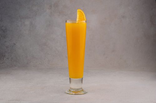 Free A refreshing glass of orange juice with a slice garnish on a neutral background. Stock Photo