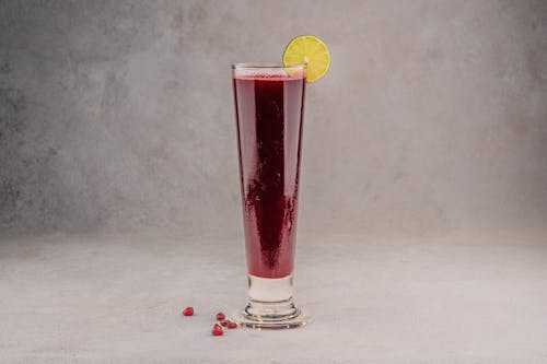 Glass of Pomegranate Juice with Lemon Slice