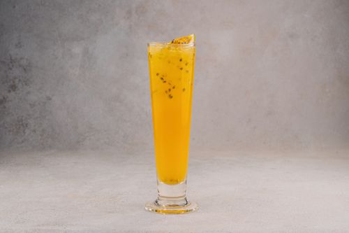 Free Chilled passion fruit cocktail in a sleek tall glass, perfect for summer refreshment. Stock Photo