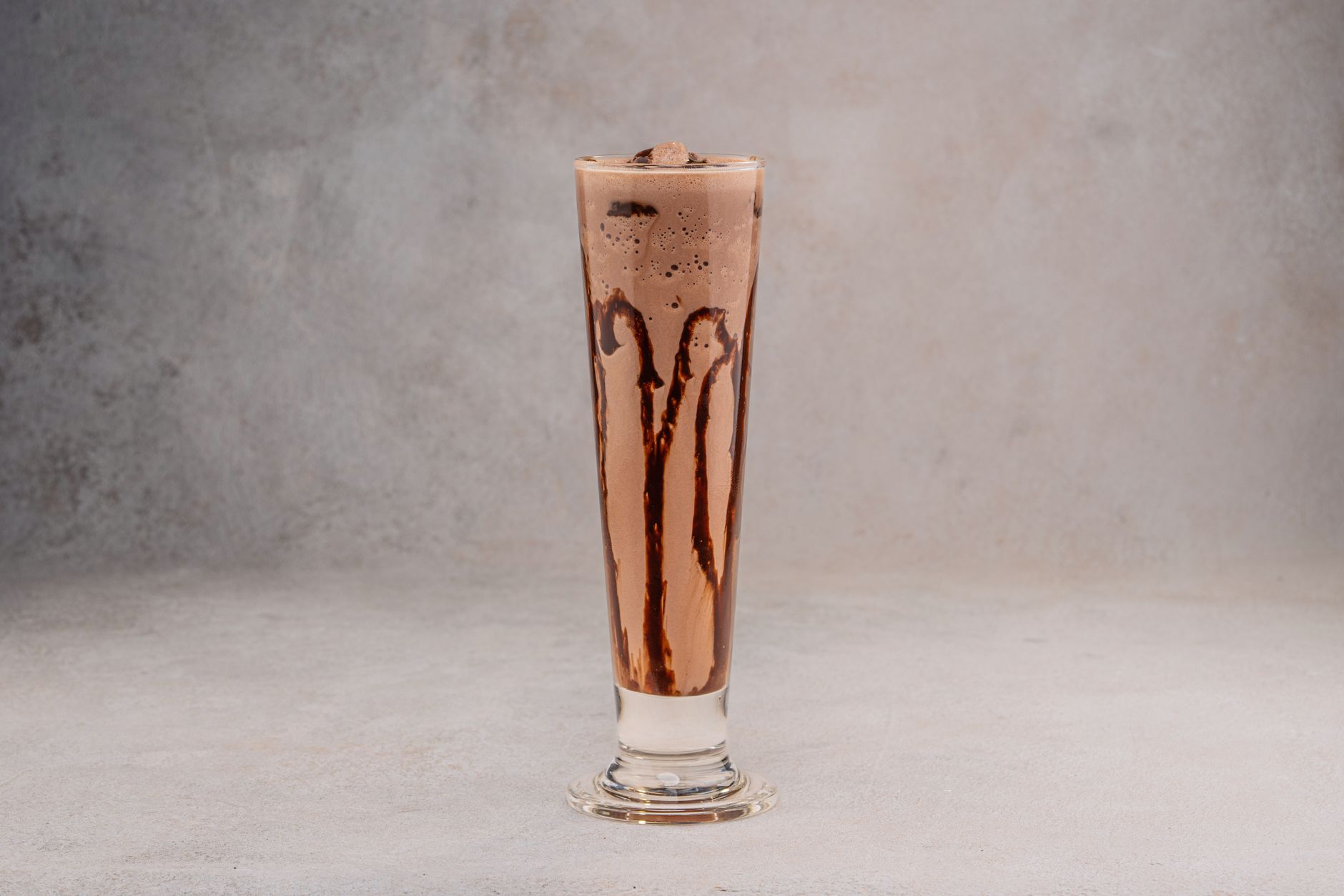 Chocolate milkshake in glass with whipped cream and straw