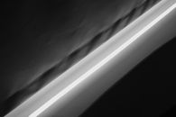 A minimalist abstract photograph highlighting the interplay of light and shadow in black and white.