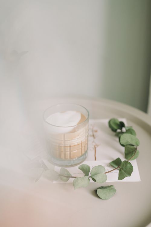 Free A cozy cappuccino with eucalyptus leaves on a table, evoking a serene vibe. Stock Photo