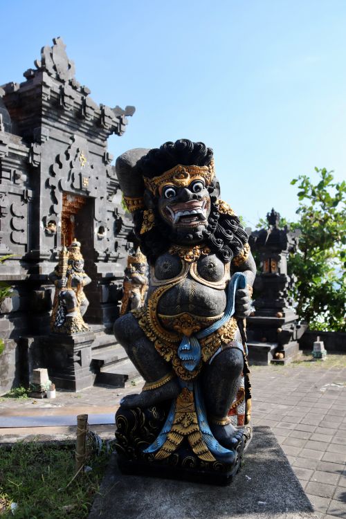 Free Close-up of a traditional Balinese statue in a temple courtyard under clear skies. Stock Photo